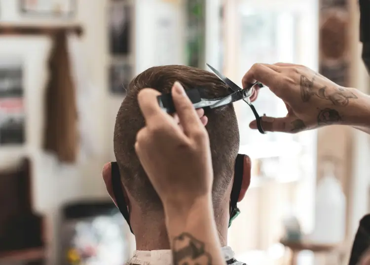Photo of a barber cutting a client's short hair.