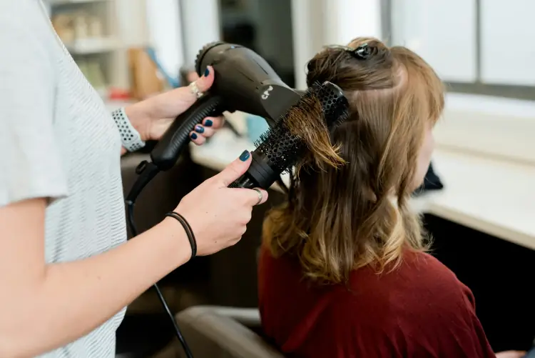 Photo of a barber performing a haircut on a client, tailored for longer lengths.