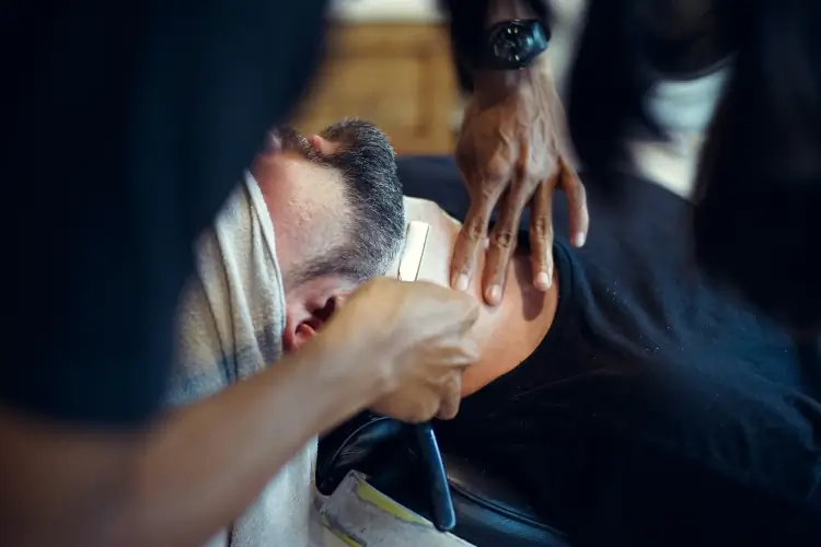 Photo of a barber shaving a client's neck.